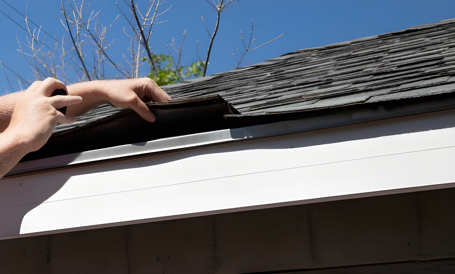 Hand lifting damaged asphalt shingle on residential roof during inspection for repair or replacement. Roof inspection in Hilton Head Island