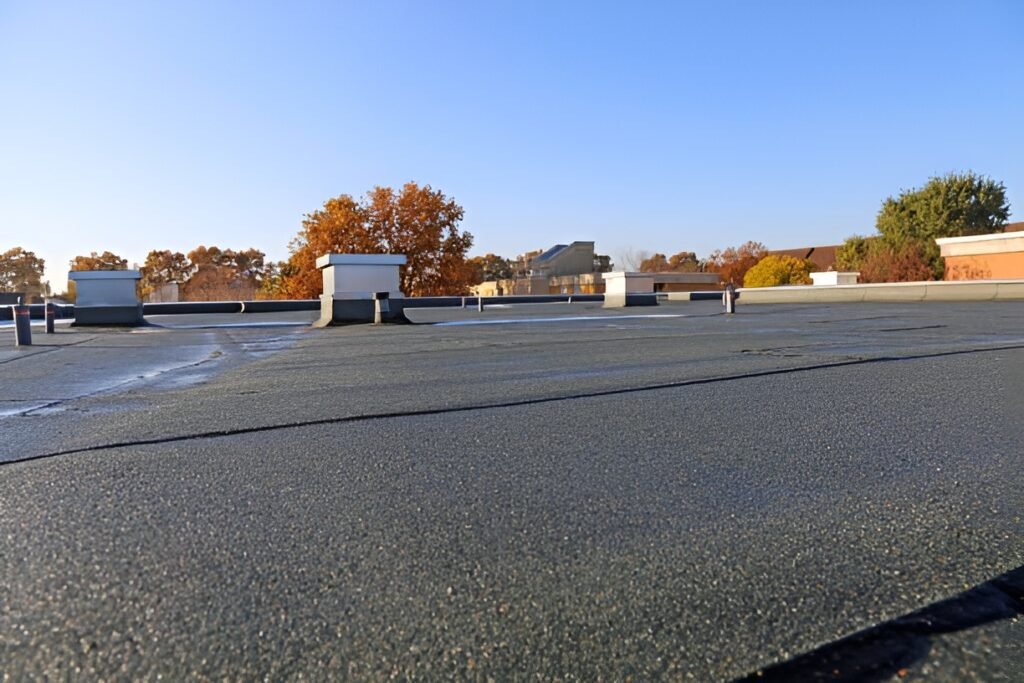 Low-slope commercial roof with protective coating and rooftop vents on a clear day. Flat roofing in Bluffton.