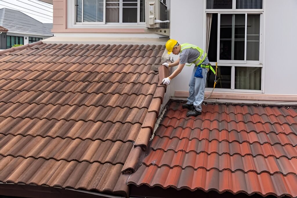 Worker fixing eaves and tiles of the old roof.